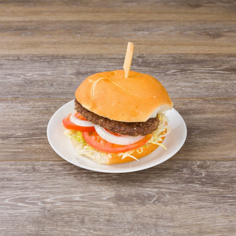 A Paradise Deli & Grocery burger with patty, lettuce, tomato, and onion on a white plate.
